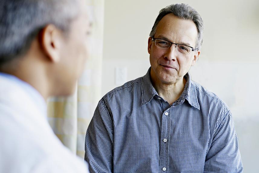 Male patient talking to doctor in office