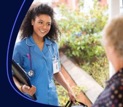 A women opening her front door to a smiling nurse. 