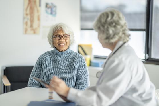 Doctor and smiling female patient talking in office