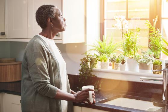 Woman looking out kitchen window